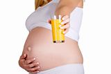 Presenting glass of orange juice in front of pregnant belly