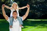 Father With Daughter On Shoulders Having Fun In A Park