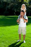 Father With Daughter On Shoulders Having Fun In A Park