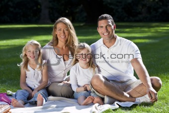 Happy Family Having Picnic In A Park