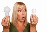 Funny Faced Woman Holds Energy Saving and Regular Light Bulbs Isolated on a White Background.