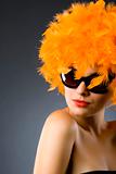 pretty woman wearing an orange feather wig and sunglasses