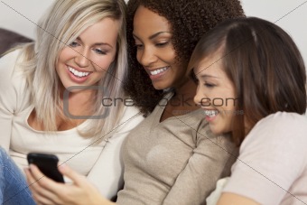 Three Female Friends Laughing and Looking at Cell Phone