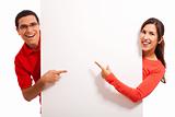 Happy young couple pointing to copy space