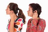 Two woman putting hearing aid into ear 