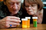 Man and woman looking at prescription medications