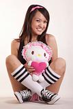 Young woman holding doll wearing pink casual shorts