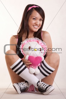 Young woman holding doll wearing pink casual shorts