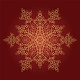 Golden detailed snowflake on red background