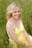 Beautiful Blond Woman Sitting In Tall Grass