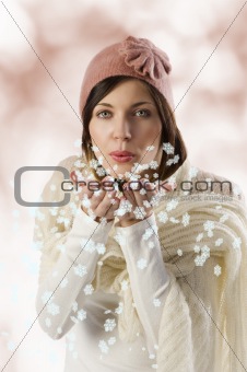 sweet girl blowing on snow flakes