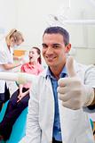 friendly male dentist giving thumb up sign