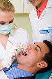 dentist and assistant working on male patient