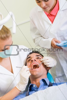 dentist and assistant working on male patient
