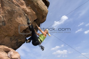 Young woman climbig a rock