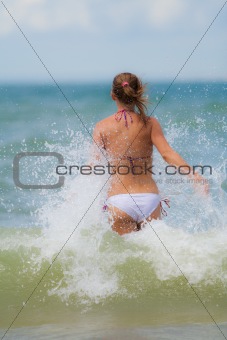 Girl running towards waves