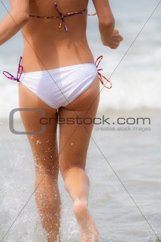 Girl running towards waves