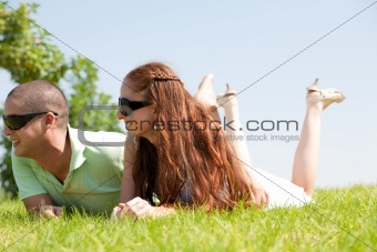beautiful young Couple lie down on grass