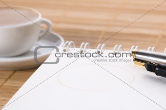 pen, notebook and cup of coffee