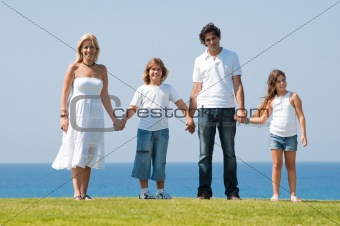Family of four holding hands