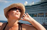 Beautiful Vacationing Woman on Tender Boat with Cruise Ship in the Background.