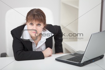 Resolutely woman - managing director sits at table with laptop