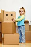 Little girl with lots of cardboard boxes grimacing
