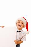 Laughing christmas boy with santa hat and blank sign