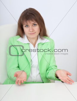 Woman sitting at table with astonishment makes helpless gesture