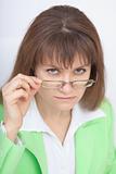 Serious woman - teacher looks at us over glasses