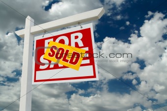 Sold For Sale Real Estate Sign on Cloudy Sky.