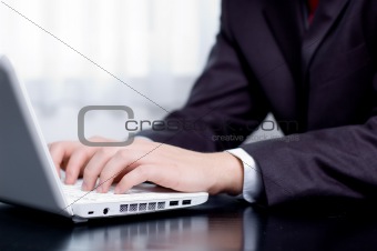 Businessman typing on a notebook