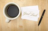 Good Luck Note Card, Pen and Coffee Cup on Wood Background.