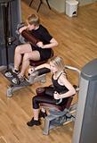 Boy and a girl using excercise machines