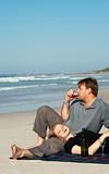 Young couple enjoying the wine on the beach