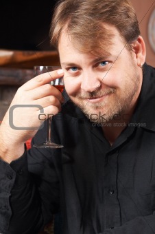 Handsome young man drinking wine