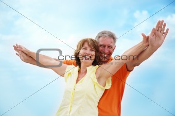 Mature couple with arms outstretched