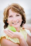 Beautiful mature woman holding an apple