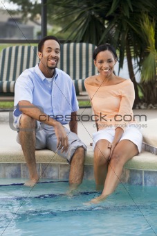 Happy African American Couple Sitting With Feet In Swimming Pool