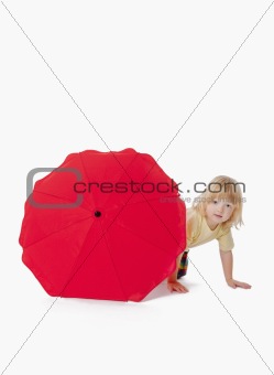 boy with long blond hair plaing with a red umbrella