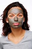 A funny girl with  mud mask on a white backgroung 