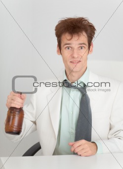 Young man at office with a beer bottle