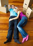Happy couple relaxing on the floor. Moving house