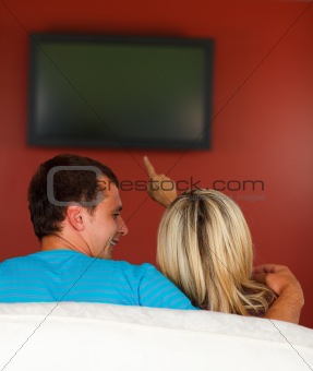 Lovers watching a television at home