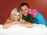 Couple on sofa holding a rose bouquet