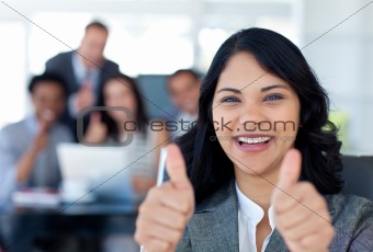 Portrait of a businesswoman with thumbs up in office