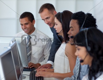 Manager helping his business team in a call center
