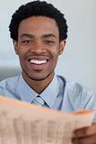 Afro-American businessman with a newspaper smiling at the camera