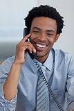 Portrait of smiling Afro-American businessman on phone in office