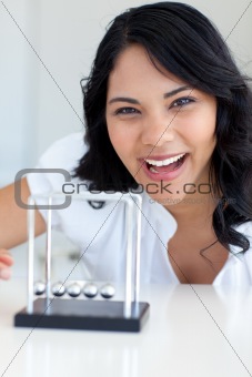 Smiling businesswoman playing with Newton balls